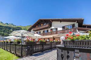 a building with an umbrella and flowers on a deck at Hotel Bünda Davos in Davos