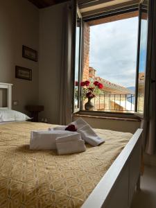 Una cama en un dormitorio con una ventana grande. en Casale21, en Castiglion Fiorentino