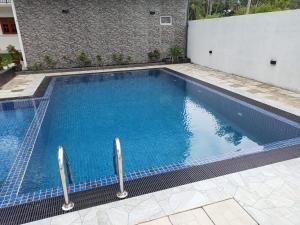 a swimming pool with blue water in front of a building at Moonlit resort in Minuwangoda