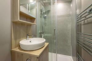 une salle de bain avec un lavabo et une douche en verre dans l'établissement Bower Lodge 135, à Cameron 15 autres photos
