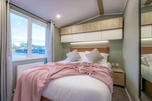 - une chambre avec un lit doté d'une couverture rose et d'une fenêtre dans l'établissement Bower Lodge 135, à Cameron