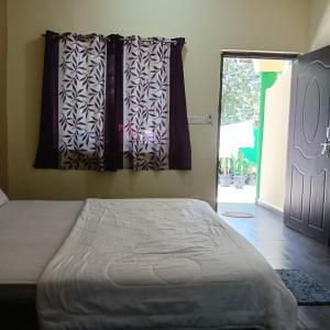a bedroom with a bed and a window and a door at One love guest house morjim in Arambol +4 photos