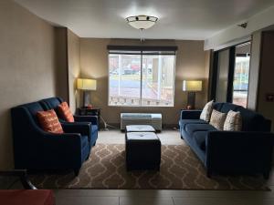 a living room with two blue couches and a window at Comfort Inn Falls Church - Tysons Corner in Falls Church +51 photos