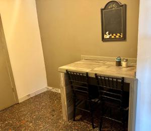 eine Theke in einem Zimmer mit 2 Stühlen und einem Tisch in der Unterkunft Suite 3 del Centro de Cuauhtémoc Chihuahua in Cuauhtémoc