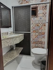 Un baño con ducha, inodoro y lavabo. en Hospedagem Quinta do Correia, en Penha