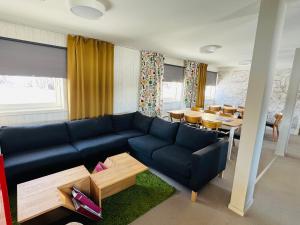 a living room with a blue couch and a table at Kittelfjäll Vandrarhem in Kittelfjäll