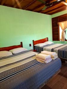a bedroom with two beds with towels on them at Eco Aldea kinich Ahau in Xpujil