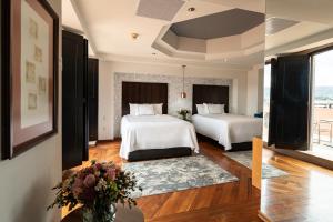 een hotelkamer met 2 bedden en een vaas met bloemen bij Santa Rita Hotel del Arte in Zacatecas +64 foto's