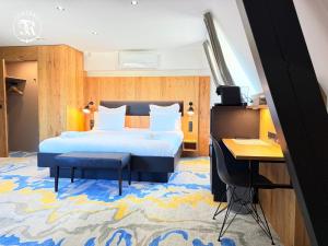 a hotel room with a bed and a desk at CHATEAU R in Wettolsheim