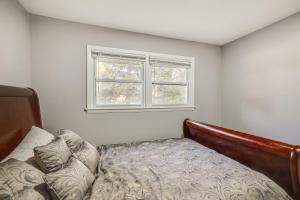 a bedroom with a bed and a window at 2 Mi to Pewaukee Lake! Peaceful Retreat with Yard in Pewaukee