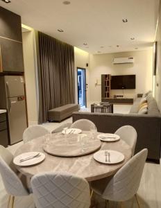 a living room with a table and chairs and a couch at اجواء الريف لبيوت العطلات in Dammam