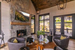 a living room with a fireplace and a stone wall at Bucks and Bunnies at Eagles Nest in Elk Park