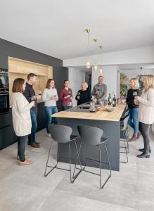a group of people standing around in a kitchen at Villa calme avec piscine et spa à Mérignac Proche hôpital tram et parc d activité in Mérignac