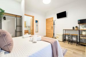 Schlafzimmer mit einem Bett mit weißer Bettwäsche und einem TV in der Unterkunft Casa Príncipe Pío in Madrid