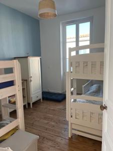 een kamer met twee stapelbedden en een raam bij Location Ile d'Oléron, plage et commerces à pieds in Le Château-dʼOléron