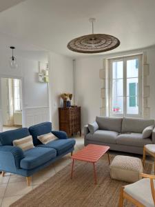een woonkamer met twee blauwe banken en een tafel bij Location Ile d'Oléron, plage et commerces à pieds in Le Château-dʼOléron +1 foto