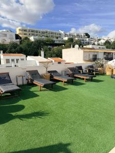 a group of benches sitting on a field of grass at Solmare Suites by Atlas in Albufeira