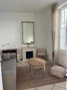 een woonkamer met een bank en een salontafel bij Location Ile d'Oléron, plage et commerces à pieds in Le Château-dʼOléron