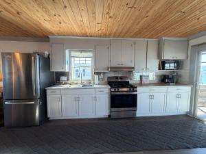 a kitchen with white cabinets and a wooden ceiling at Canal front home on 3rd St. in Surf City, NC in West Onslow Beach +13 photos