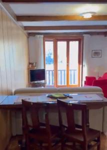 a dining room table with two chairs and a window at La casa di Marta, charme e relax in Breuil-Cervinia +23 photos