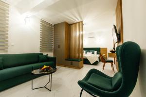 a living room with a green couch and chairs at Sahat Kula Residence Hotel in Ulcinj