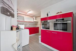eine Küche mit roten Schränken und einem roten Backofen in der Unterkunft Casita Independiente Frente al Mar in El Pris