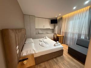 una piccola camera da letto con un letto e un divano di La Villa Bnb a Tirana