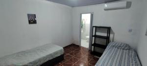 a small bedroom with a bed and a glass door at Shantti House in Pipa