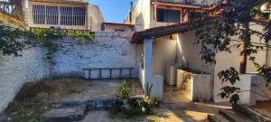 an alleyway leading into a white building with a window at Shantti House in Pipa