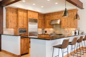 a kitchen with wooden cabinets and a bar with stools at Spacious 4BR home in Steamboat Springs, perfect for family getaways! in Steamboat Springs +10 photos