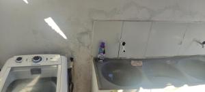 a small bathroom with a sink and a tub at Shantti House in Pipa