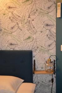 - une chambre avec un mur orné d'un papier peint à fleurs dans l'établissement A L ESCALE PASSA PAÏS, à Le Poujol-sur-Orb 3 autres photos