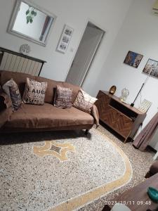 ein Wohnzimmer mit einem braunen Sofa und einem Tisch in der Unterkunft Genova House in Genua