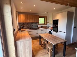 モルジヌにあるChalet "Le 19 x 27"のキッチン(木製テーブル、木製カウンタートップ付)