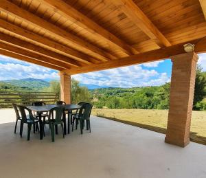 un patio avec une table et des chaises sous un toit en bois dans l'établissement La Casetta di Frank - Country House, à Chieti