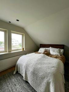 a bedroom with a bed and two windows at House Up On Ramberget In Mollösund in Mollösund +21 photos