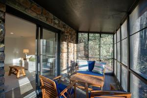 a room with a balcony with a chair and windows at Mountain Bliss at Hound Ears in Valle Crucis