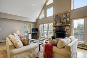 a living room with two couches and a fireplace at Four Seasons Chalet in Waterbury Center +24 photos