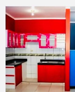 a red and white kitchen with red cabinets at Descubre un lugar pensado para ti in Sechura