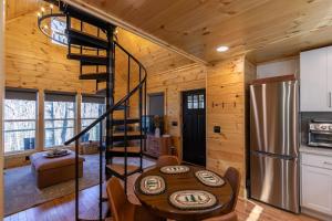 a kitchen and dining room with a spiral staircase in a log cabin at Retreat at Riverbend in West Jefferson