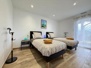 two beds in a room with white walls and wooden floors at Karrika buria in Saint-Martin-dʼArberoue