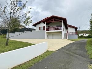 a white house with a porch and a driveway at Karrika buria in Saint-Martin-dʼArberoue