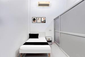 a white bedroom with a black and white bed at Hotel O Wave Inn in Jahāngīrpur