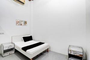 a bedroom with a bed and two shelves at Hotel O Wave Inn in Jahāngīrpur