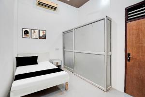 a bedroom with a bed and a sliding glass door at Hotel O Wave Inn in Jahāngīrpur