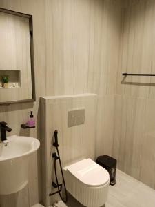 a bathroom with a white toilet and a sink at اجواء الريف لبيوت العطلات in Dammam