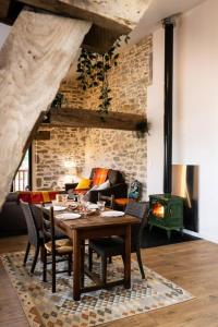 Un comedor con mesa y chimenea. en Le gite d'etxerria, en Arhansus