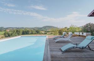 una piscina con dos sillas y una mesa en Otxibarre, en Luxe-Sumberraute