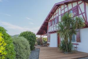 una casa con una terraza de madera con plantas en Otxibarre, en Luxe-Sumberraute