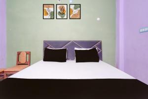a bedroom with a large bed with a purple headboard at HOTEL O AWARA GRAND PALACE in Pratāpgarh